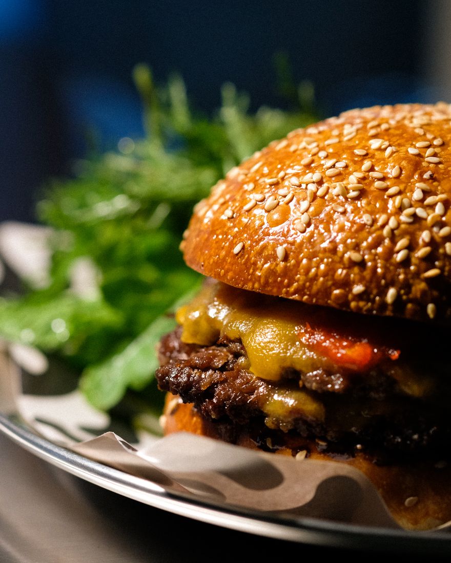The smash cheeseburger from the side: crisp patties, melted cheddar and sweet chilli jam